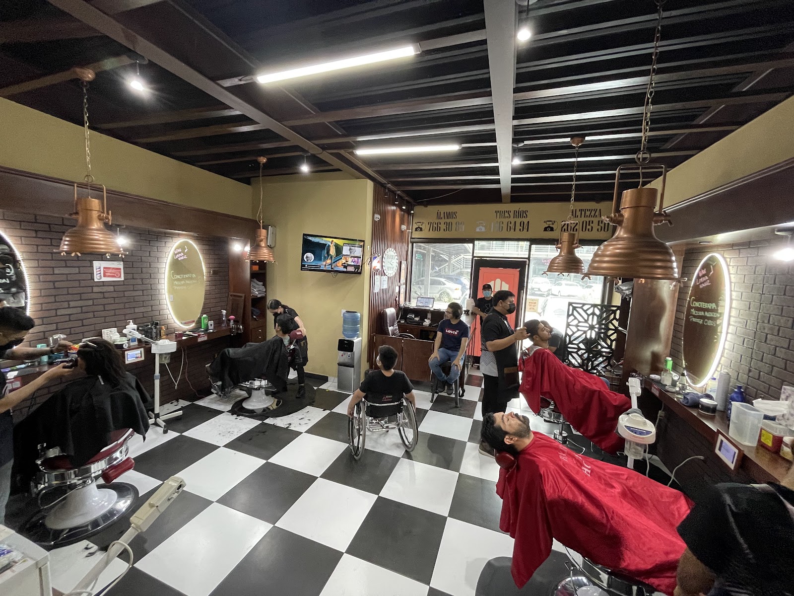 Ambiente del salón con lámparas de cobre y clientes atendiéndose