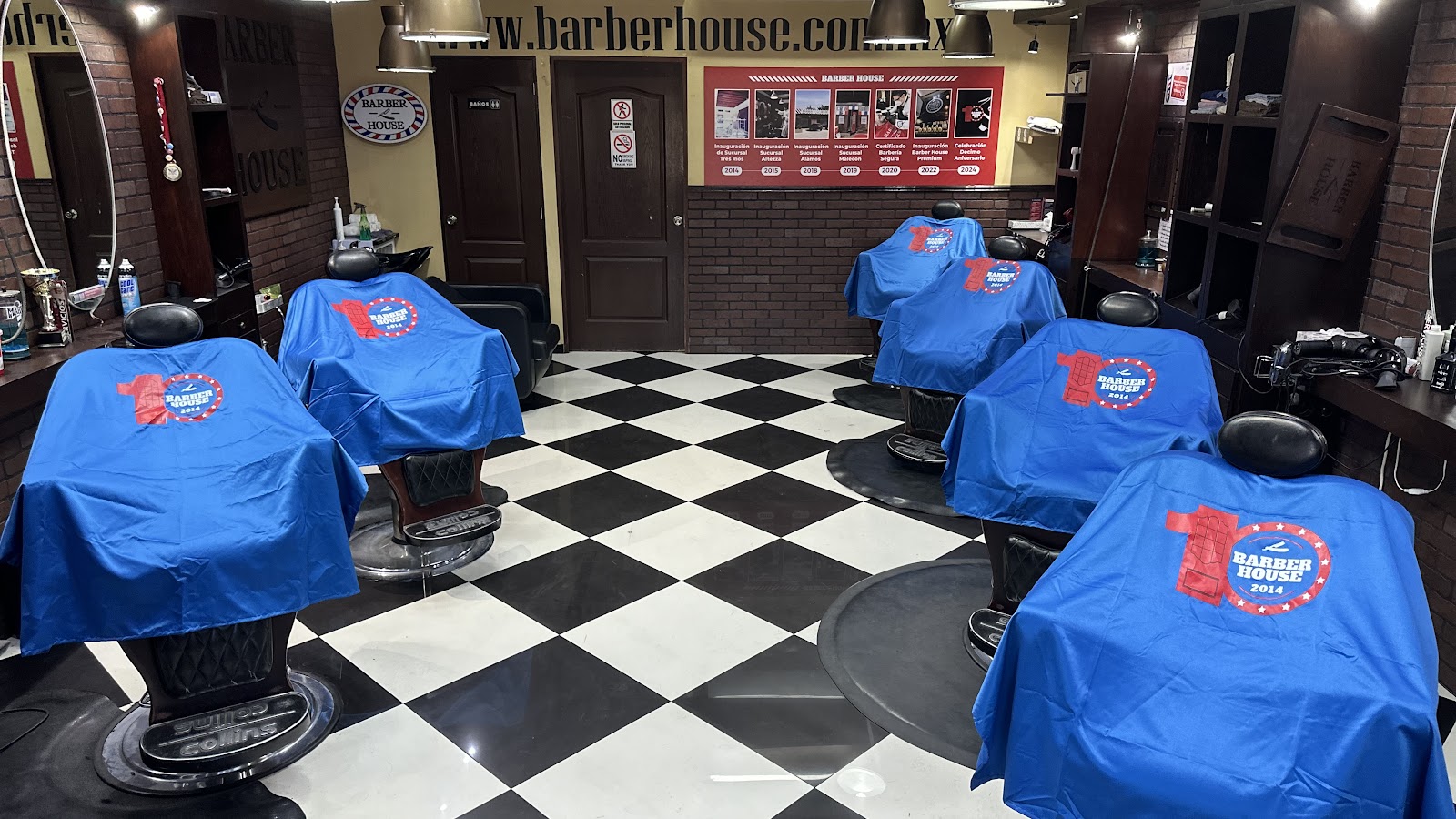 Fila de estaciones de barbería con capas y piso ajedrez
