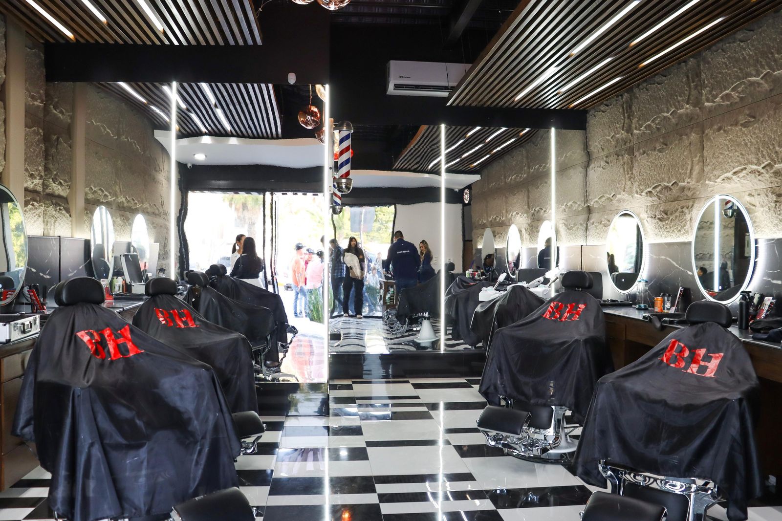 Interior premium de Barber House: espejos ovalados, mármol negro y piso ajedrez